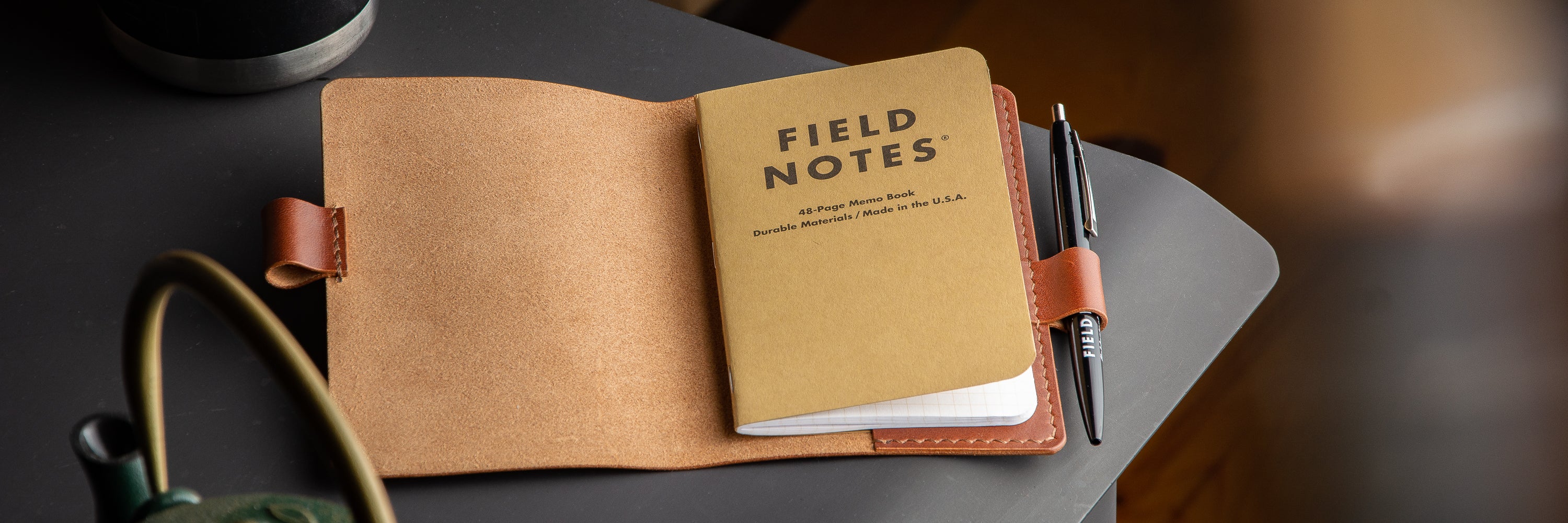 Log Carrier hanging on end of sawn logs in snowy field.