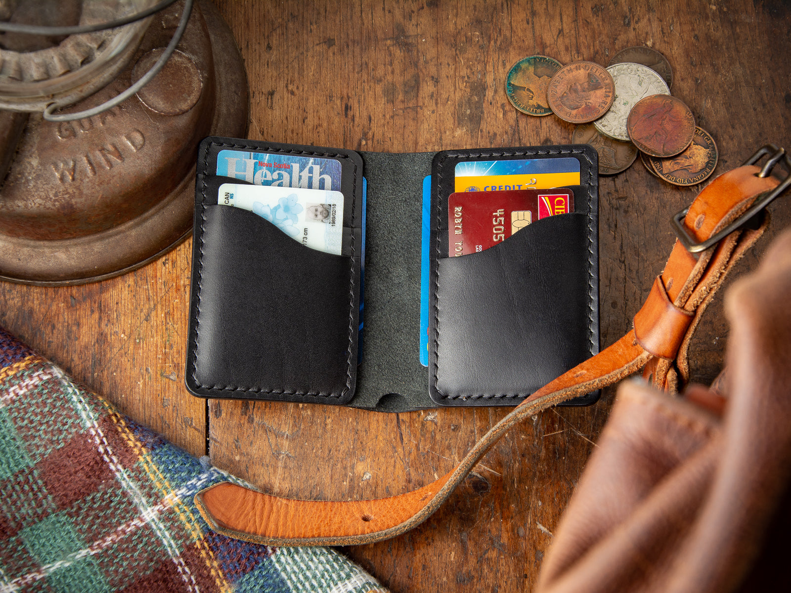 Bateston modern bi-fold wallet in black full-grain leather, open showing cards and cash