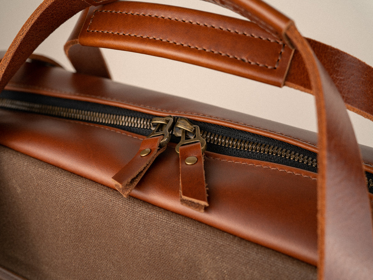 close up shot of the antique brass zipper and padded handles of the campbellton side bag