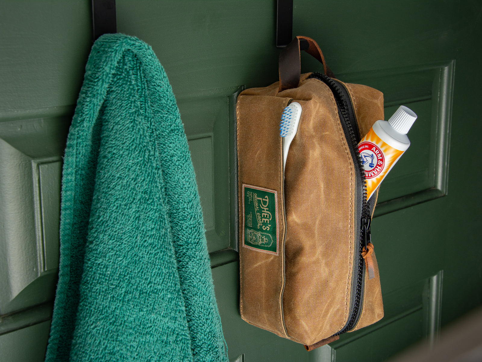 Nutmeg brown waved canvas washabuck Dopp kit hanging on a hook in a bathroom