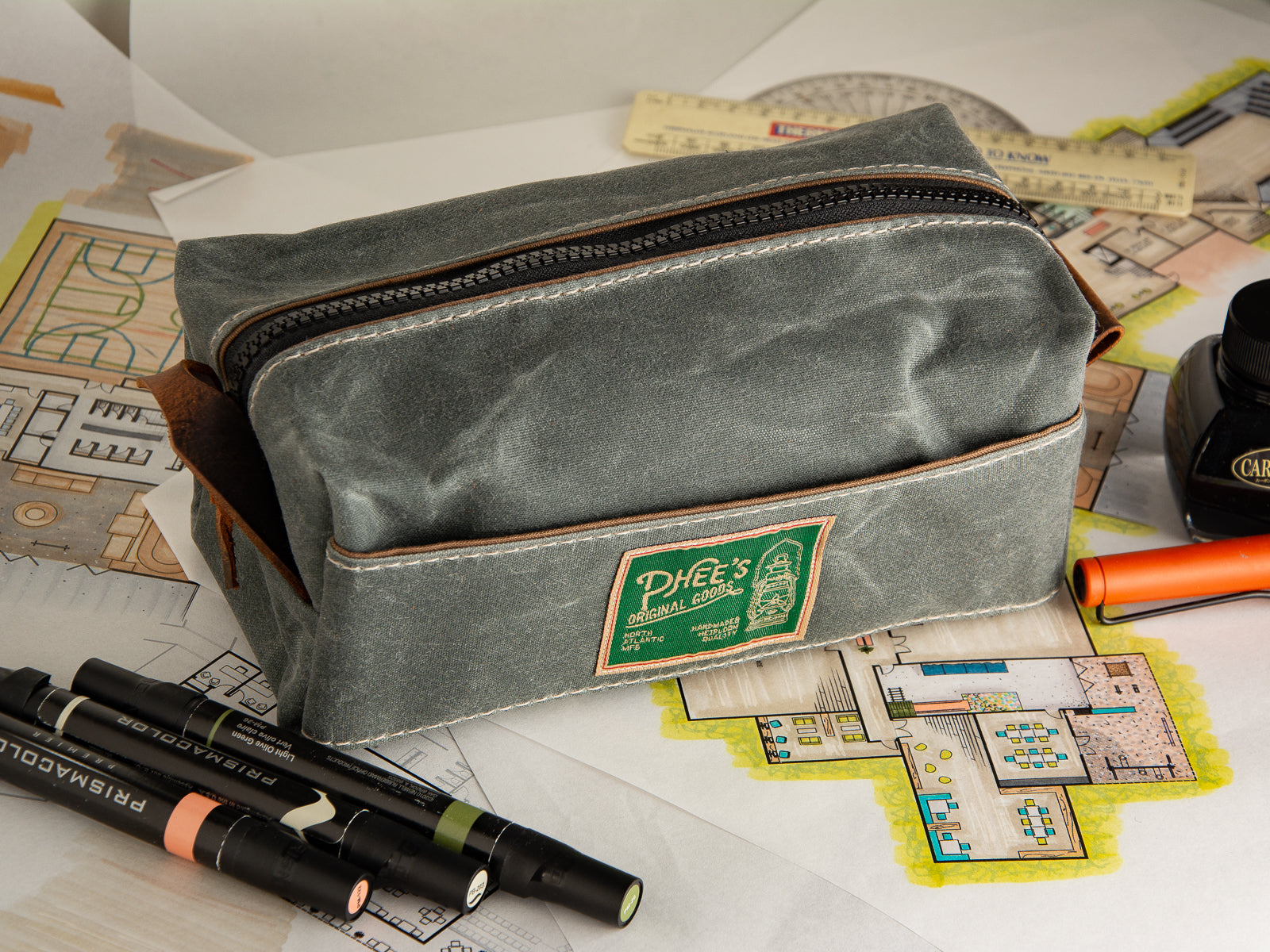 Washabuck bag in Slate grey waxed canvas everything bag sitting on a rendered plan of a building