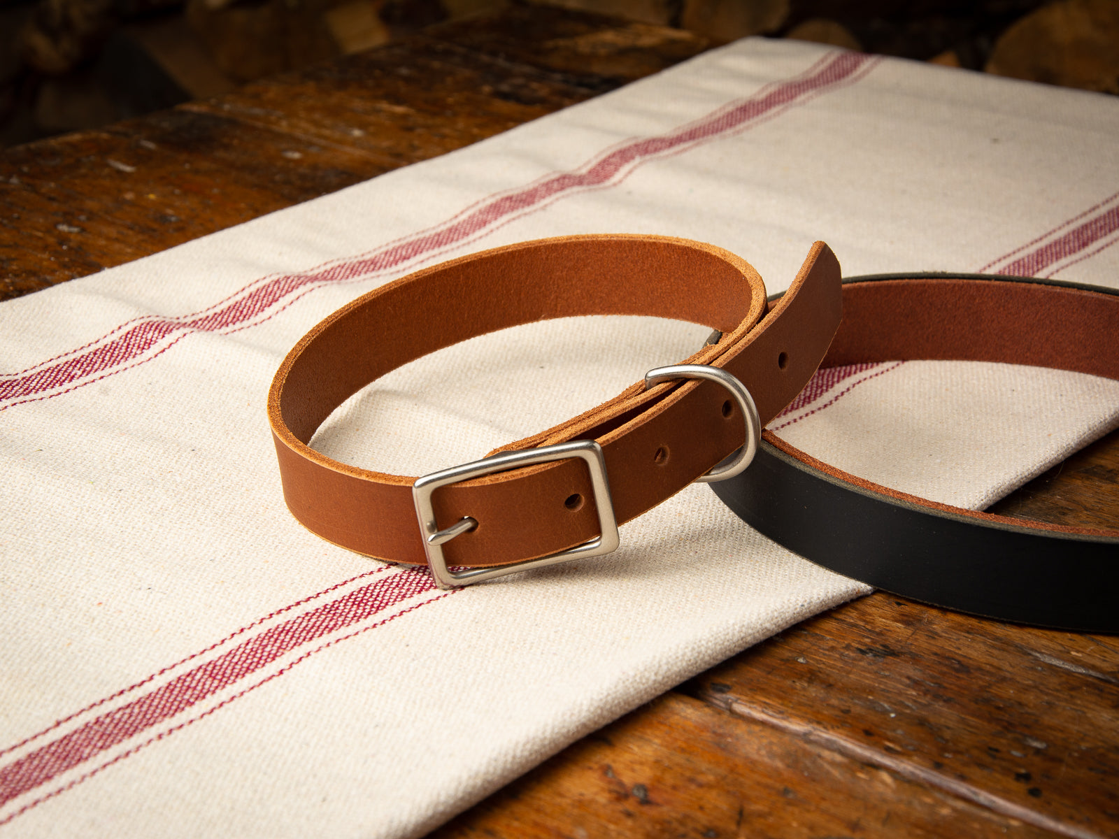 Tan coloured leather veg-tan dog collar sitting on a table