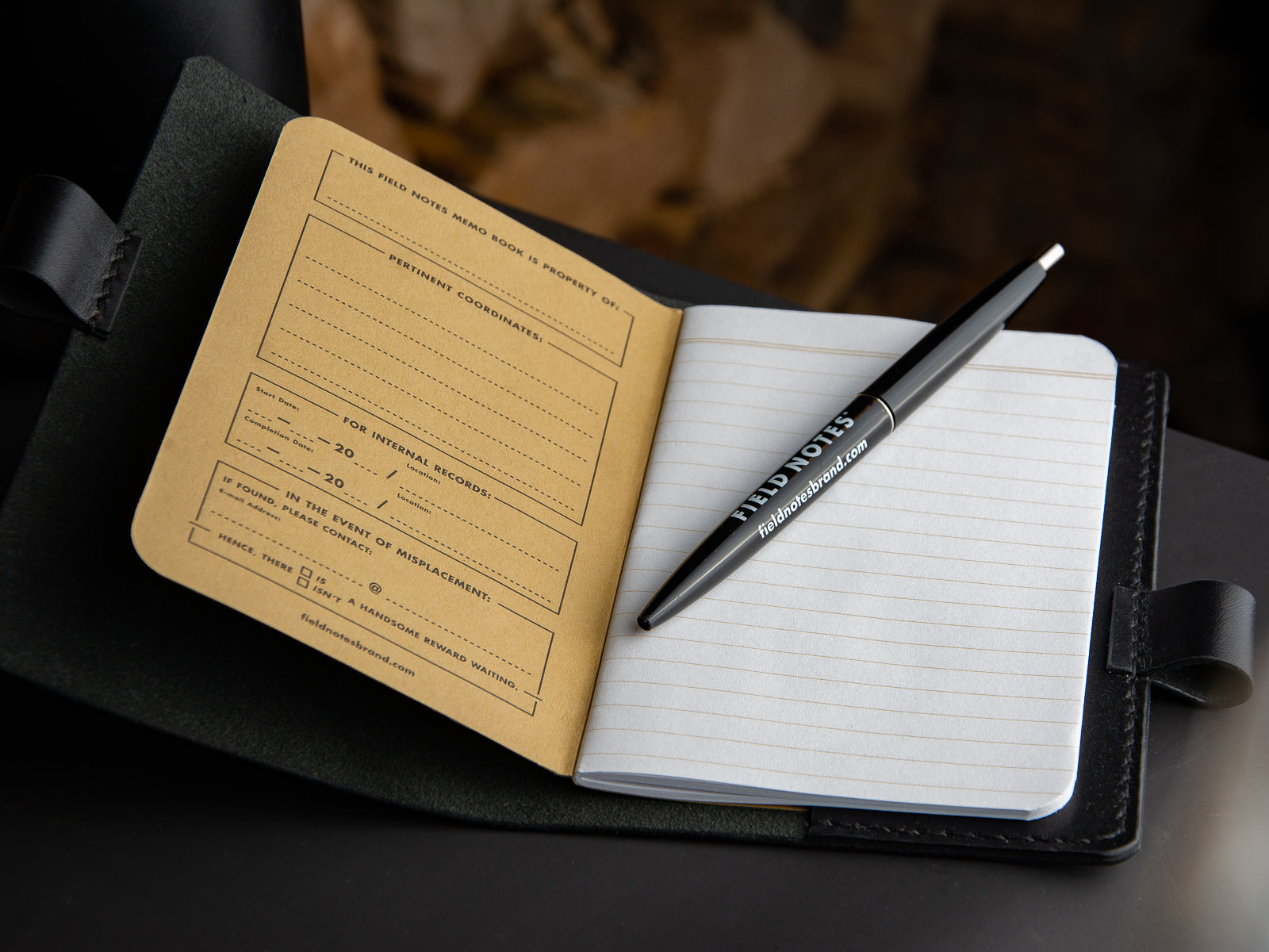 Black notebook sleeve sitting open showing field notes notebook