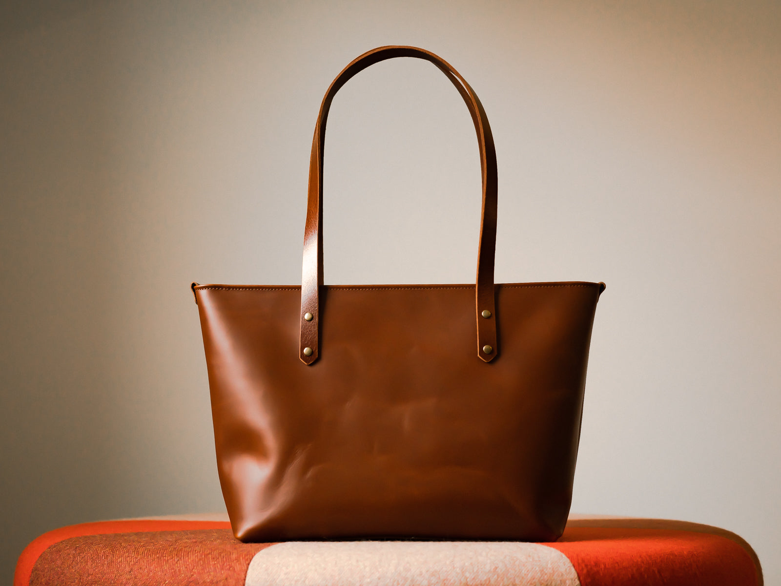 Chestnut tan leather Grand Etang tote bag with a neutral background