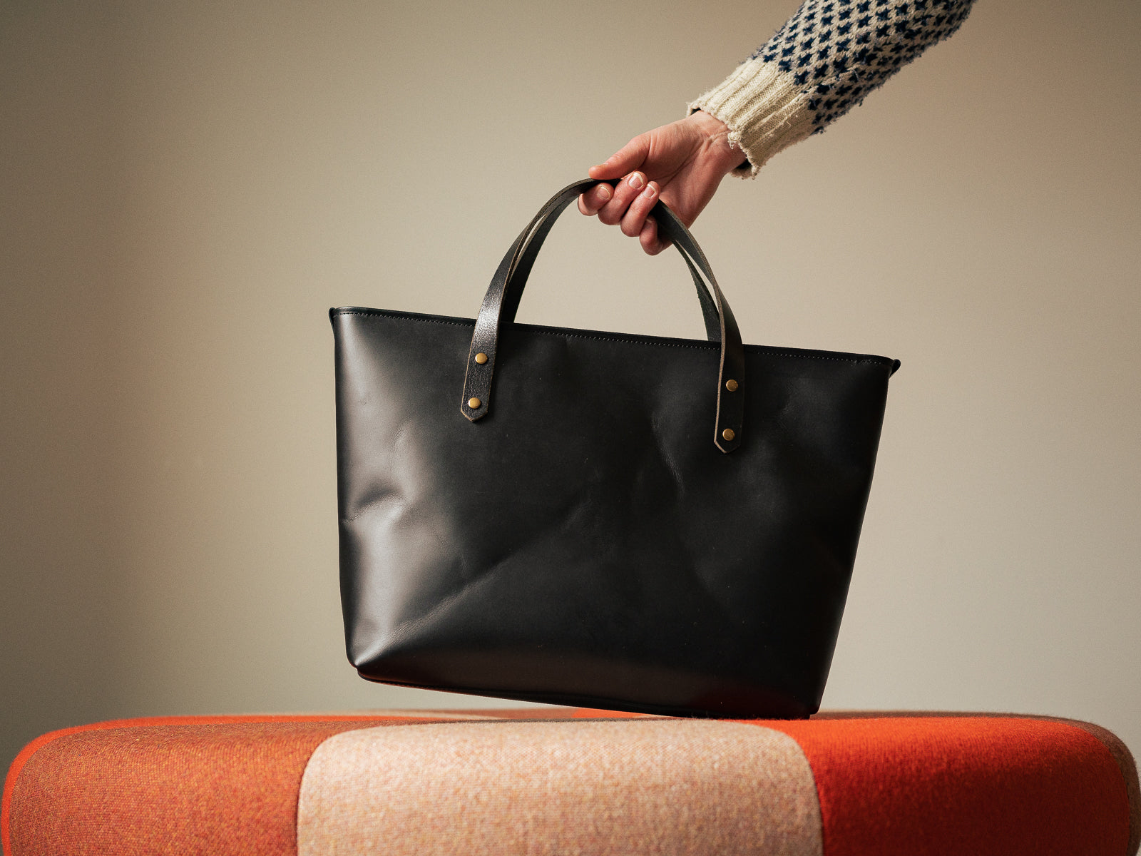 Black leather Grand Etang bag with short handle held in hand