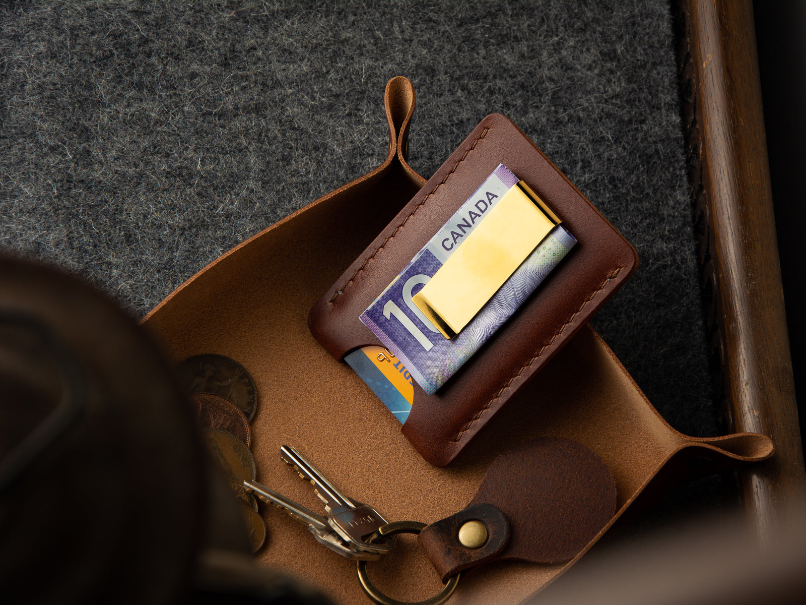 minimalist front pocket lewis leather wallet with gold finish money clip sitting in a valey tray with keys