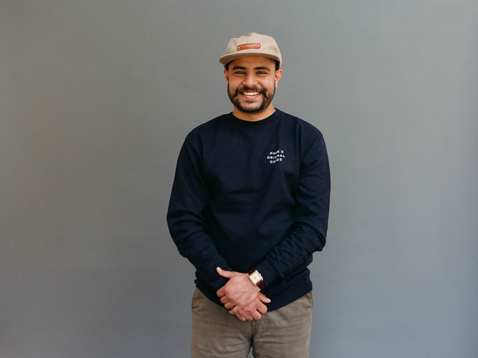 Shubham looking at the camera with a khaki North Atlantic Hat with leather patch and gold embossing