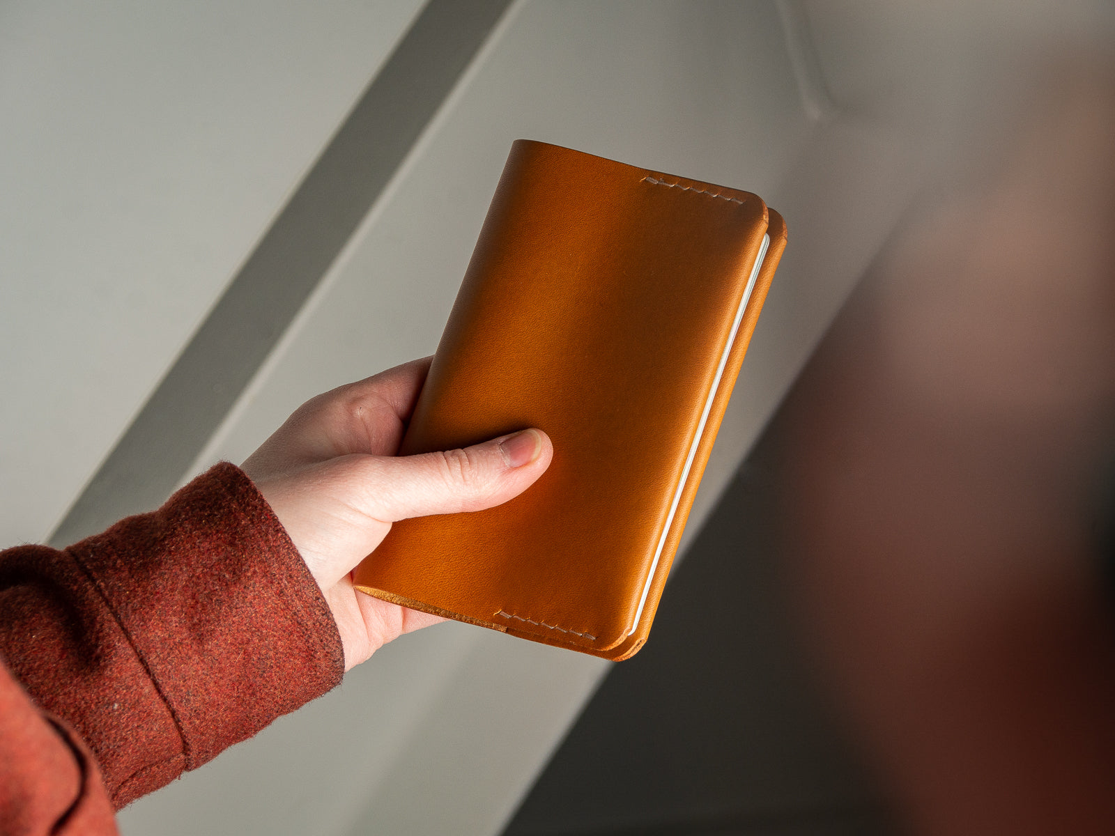 Front of tan leather passport sleeve with handstitching