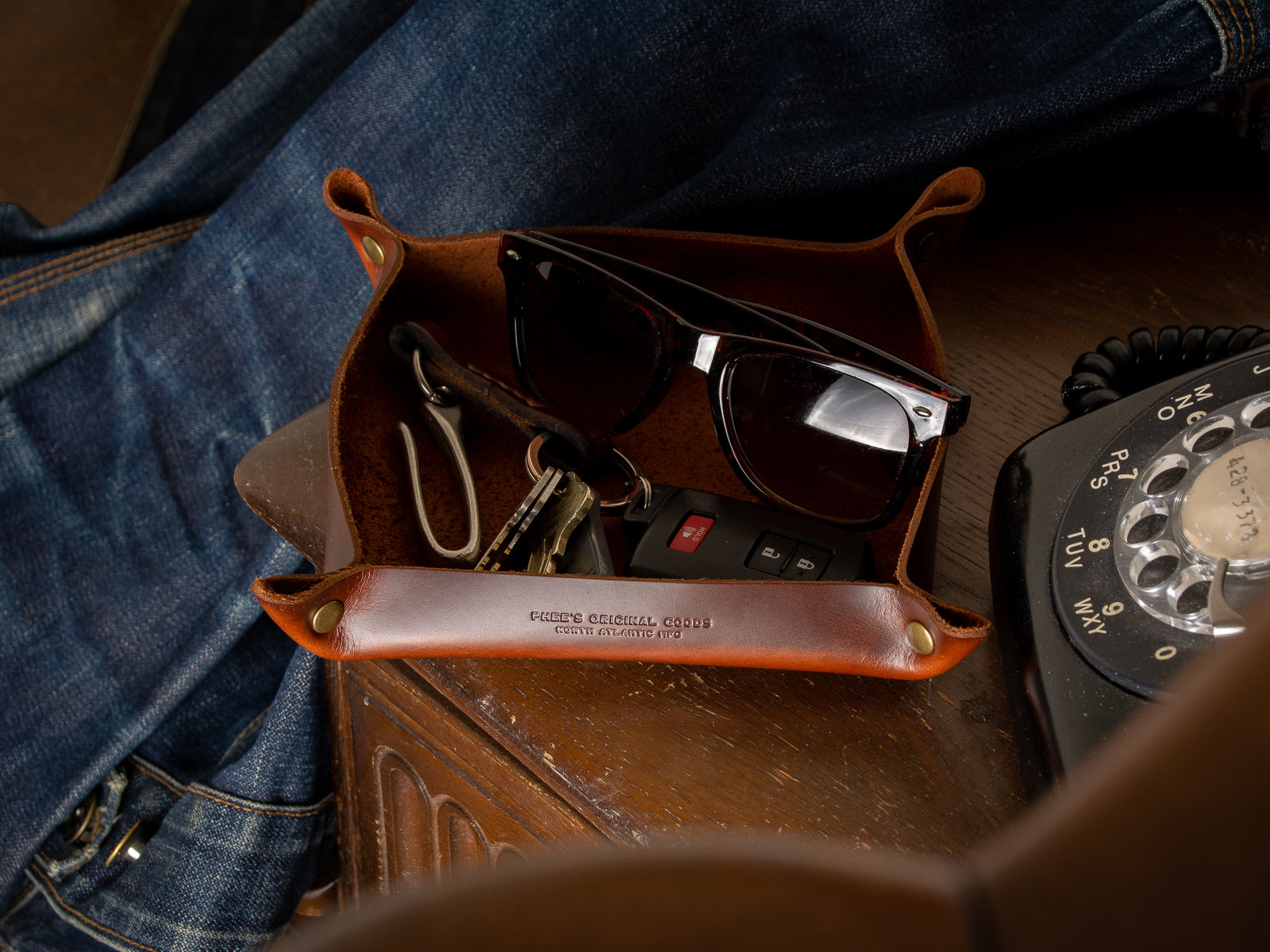 A brown home decor valet tray in full grain leather sitting in a porch