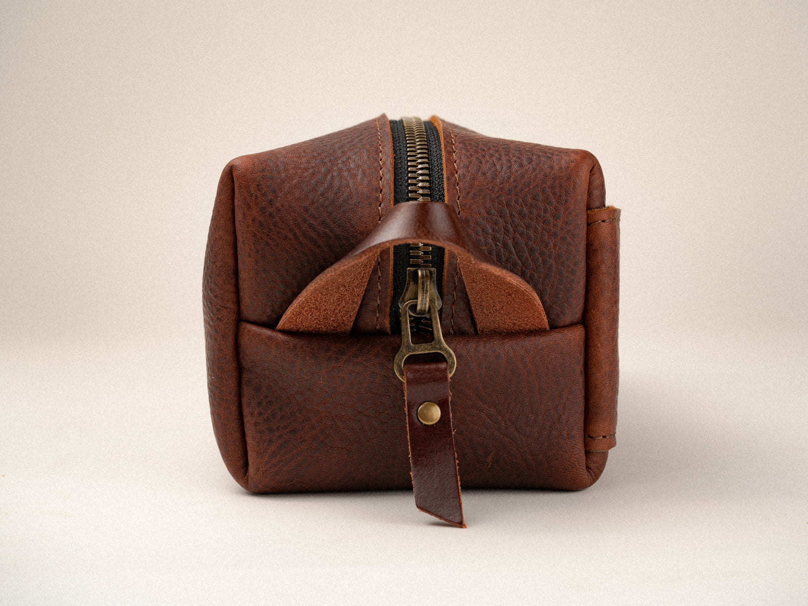 End of washabuck brown leather dopp kit, showing antique brass zipper