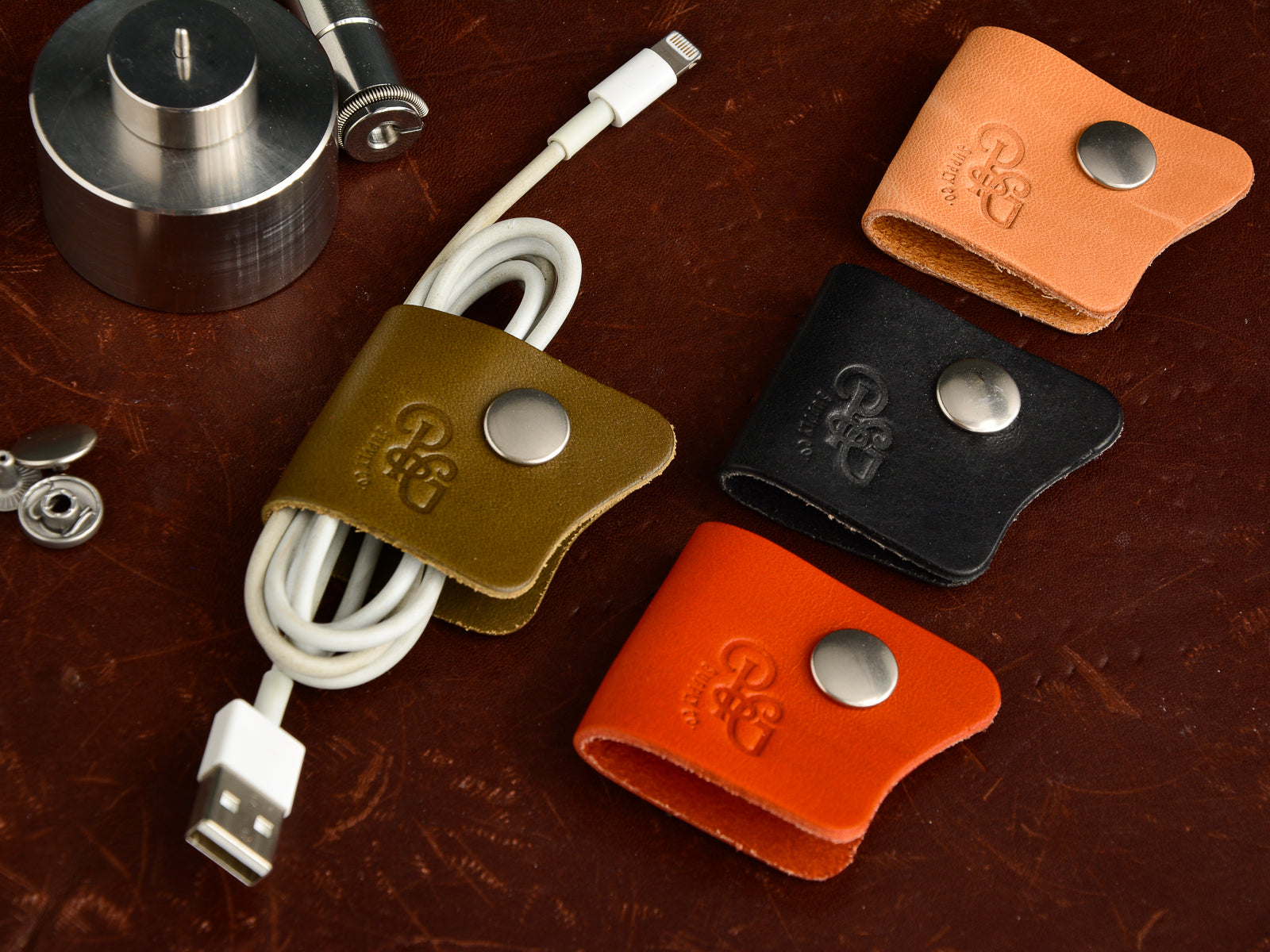 Leather cord keep with snap in olive, russet, black and orange