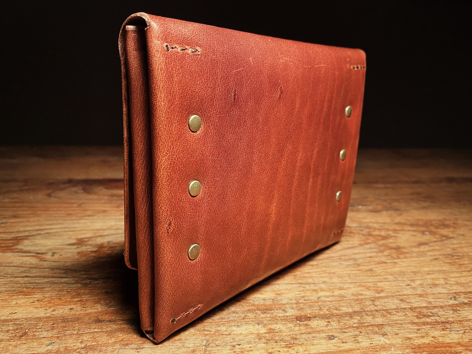 back side of fly fishing wallet in veg-tan leather with solid brass rivets