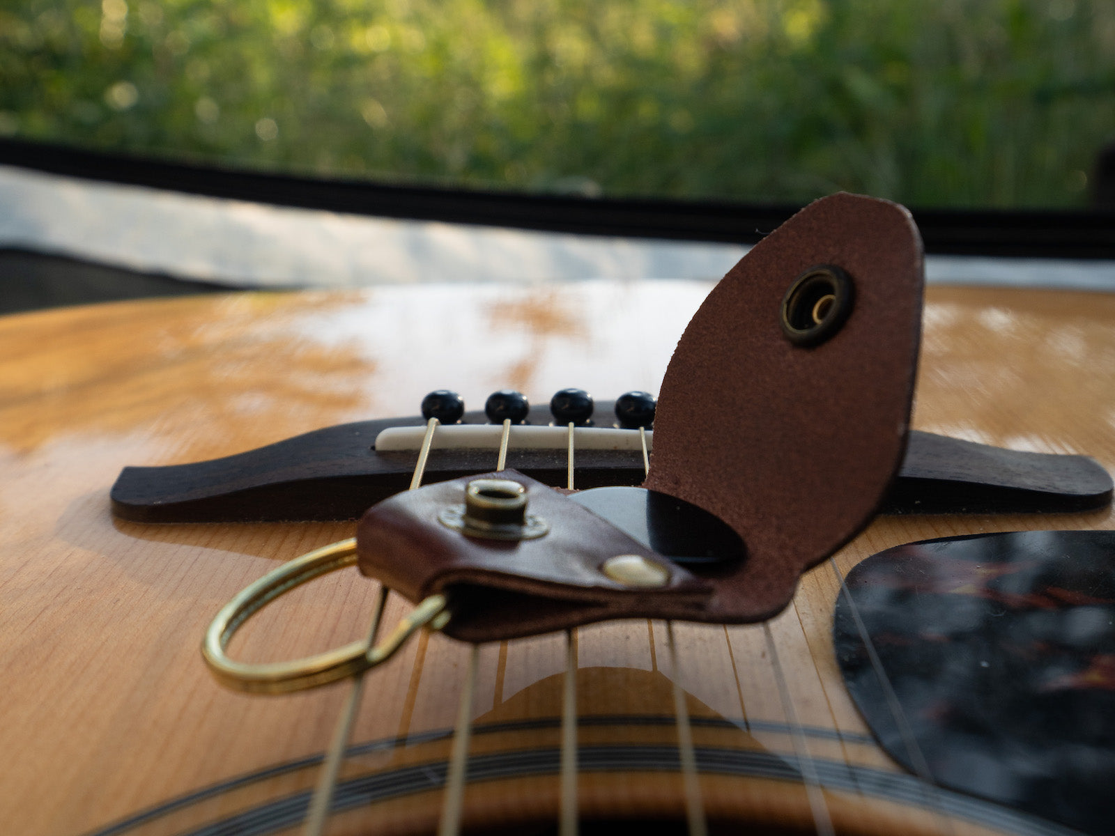 Guitar pick keeper sitting on a guitar