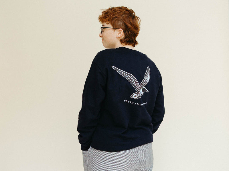 Mads showing the back of the navy Gull Crew Sweater with screenprinted seagull logo
