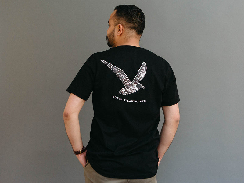 Back of the Gull Tee Shirt in black, showing screen printed seagull with the slogan "North Atlantic MFG"