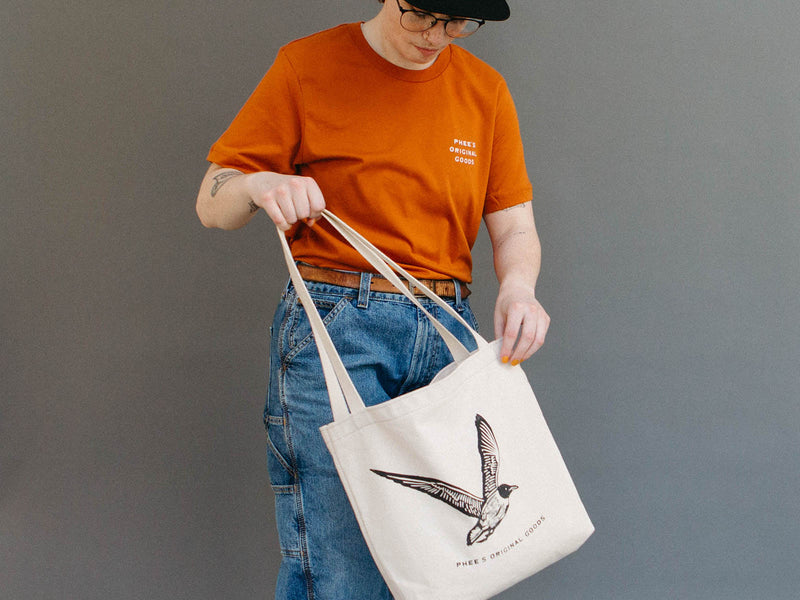 Mads swinging around a natural canvas gull tote bag