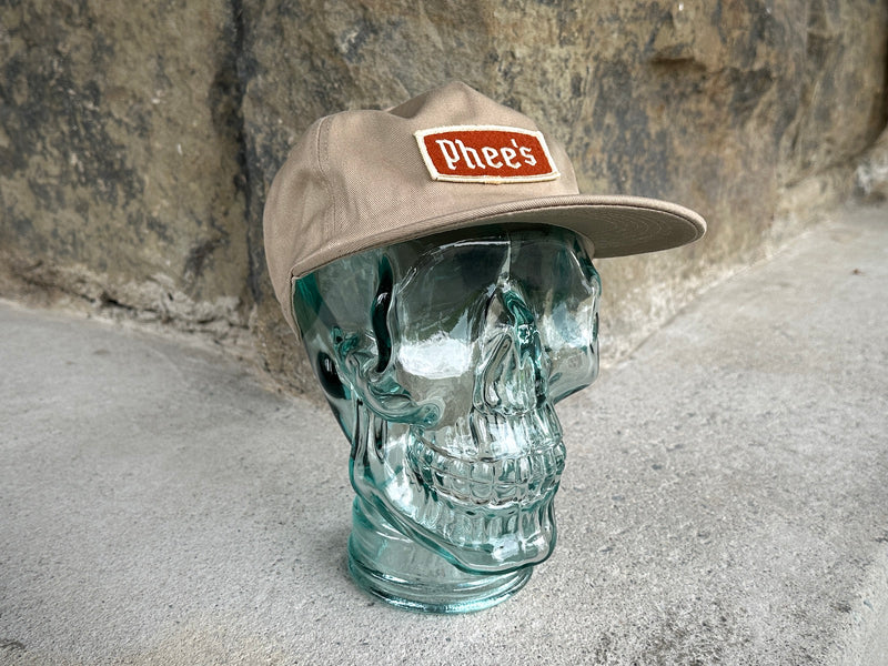 Phee's Badge Hat in Khaki with embroidered orange felt patch on a glass skull