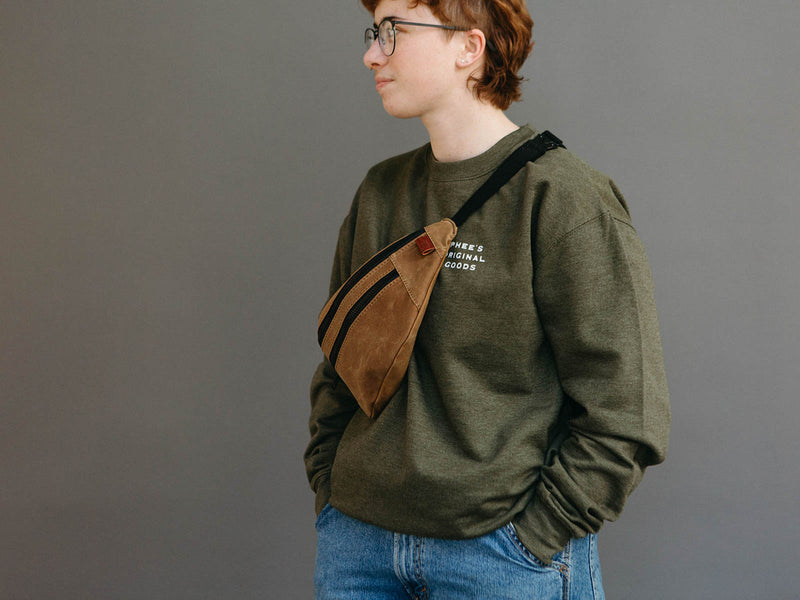 Heather olive Gull Crew neck cotton/poly sweatshirt with fanny pack slung over their shoulder.