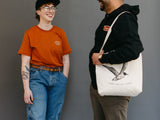 Two people laughing, one with a Gull Canvas tote slung over their shoulder