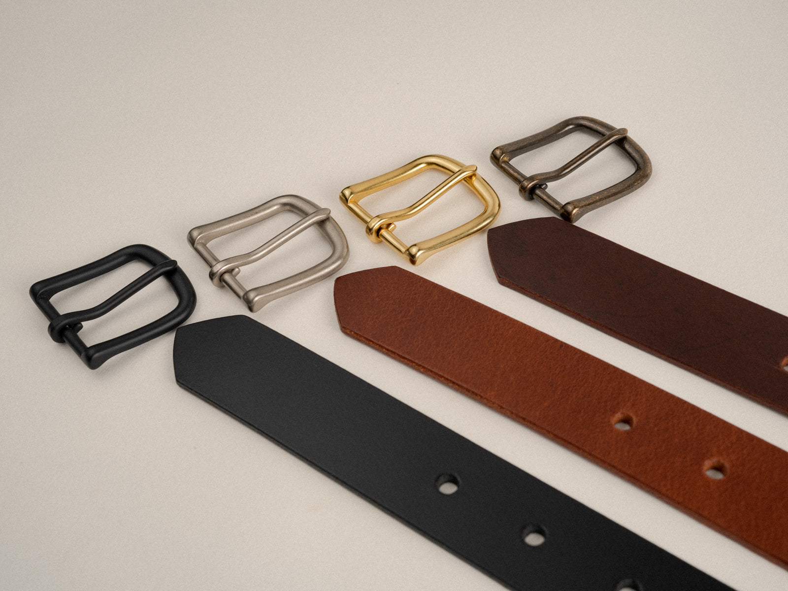 Photo showing 4 solid brass hardware finishes (black, nickel, natural brass and antique brass) alongside 3 leather options (black, tan and brown)