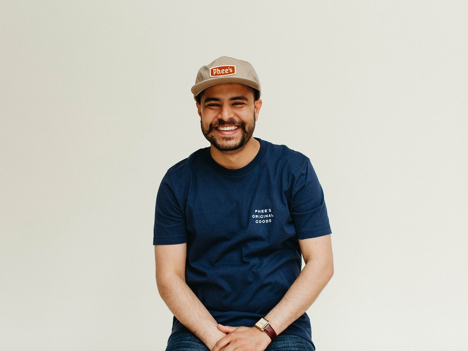 Shubham having smiling wearing a khaki Badge Hat