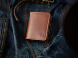 Brown leather, handstitched Barra wallet sitting on a denim jacket