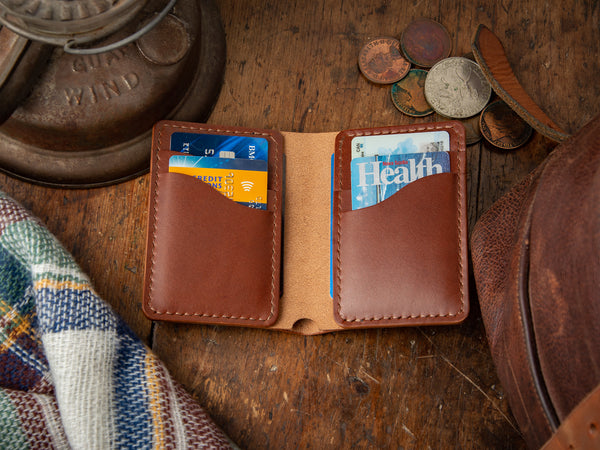 Bateston full-grain leather classic bifold, open on a table showing cards and cash