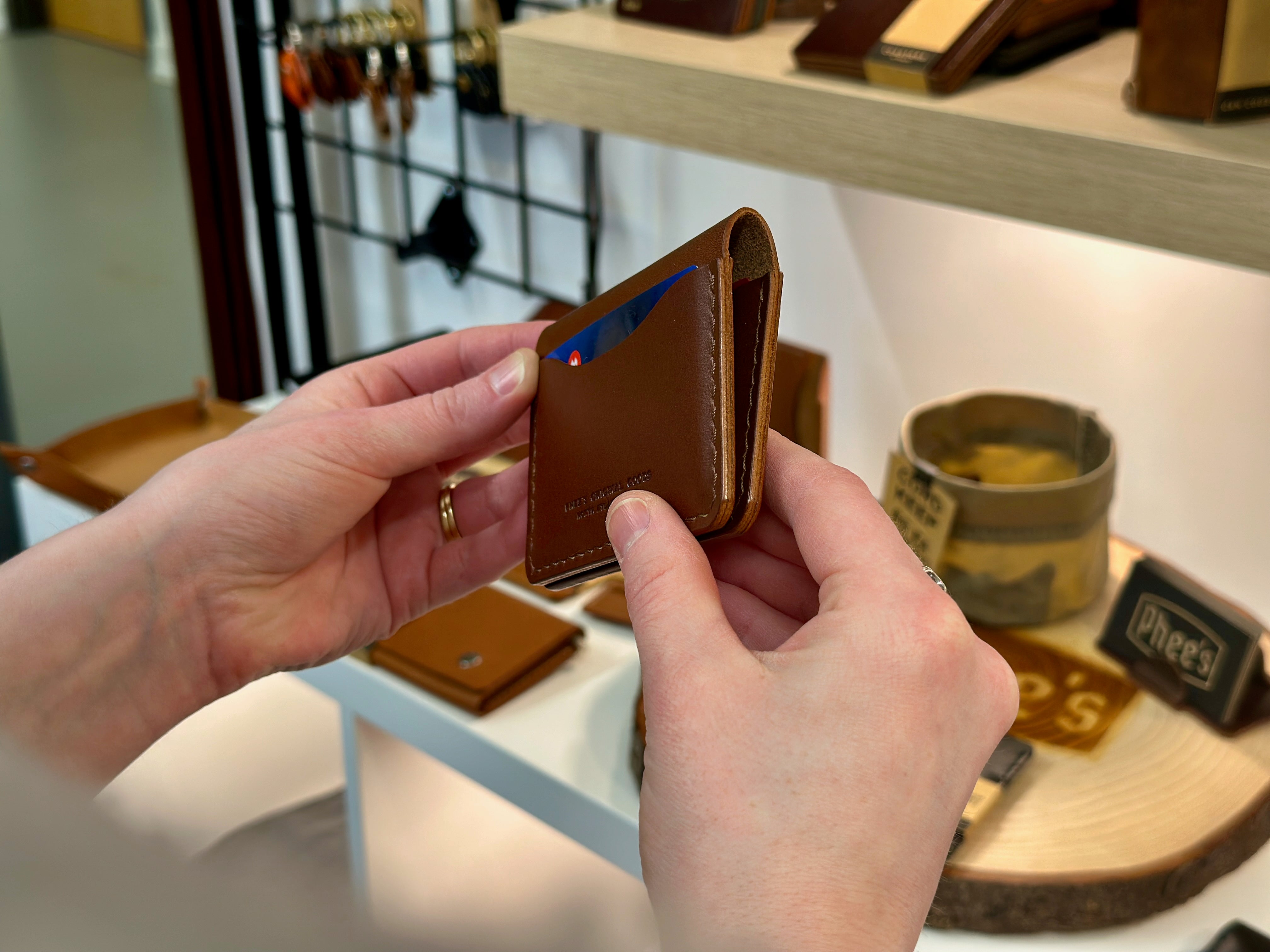 Brown belfry wallet held to show the leather burnished edges