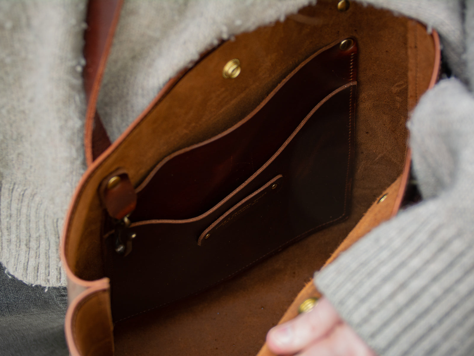 Interior of Big Bras d'Or bag in brown showing multiple pockets and keychain included.