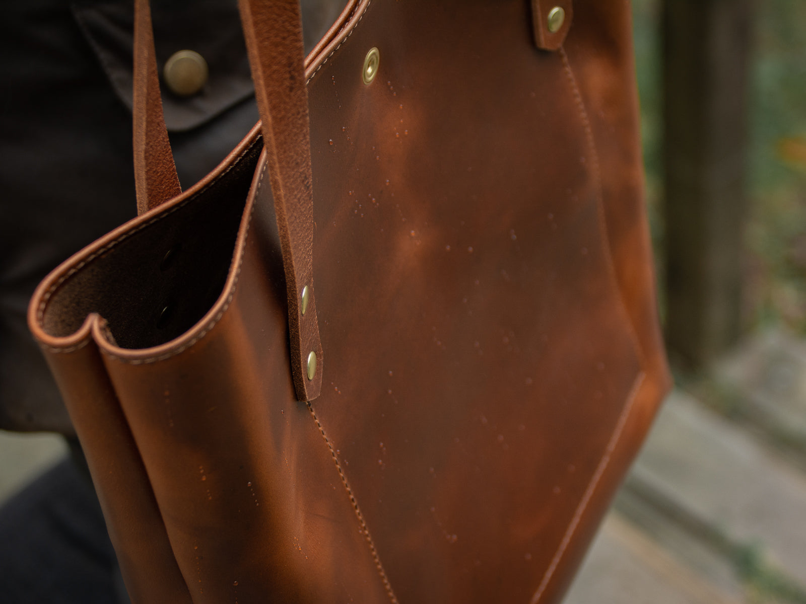 Exterior of Big Bras d'Or leather tote bag in tan colour. Shown as a closeup picture with rain on exterior of full grain leather.