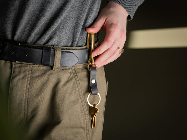 Brass fish hook keychain in black hooked on belt