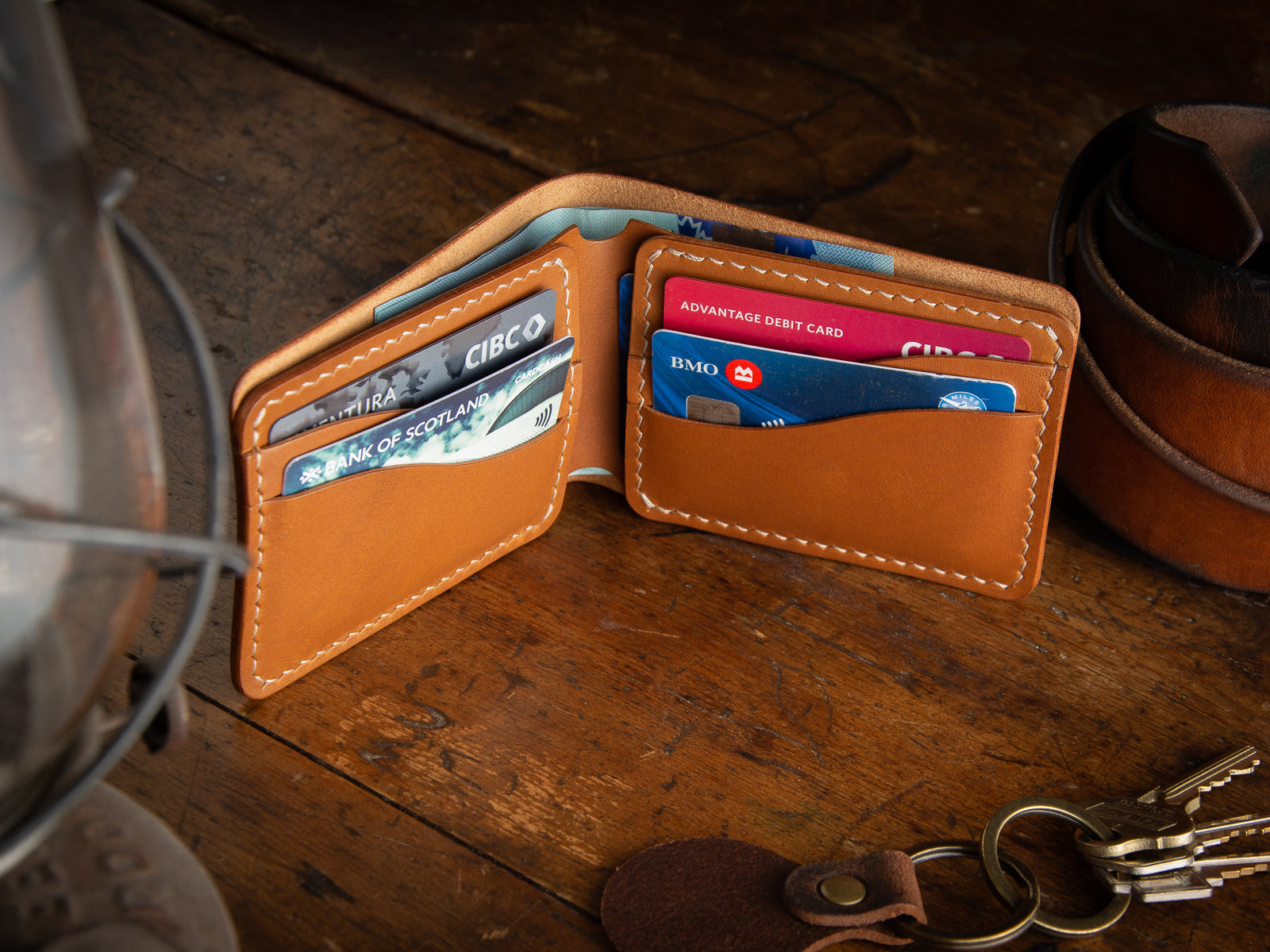 Bucklaw bifold wallet in tan - laying on rustic table 