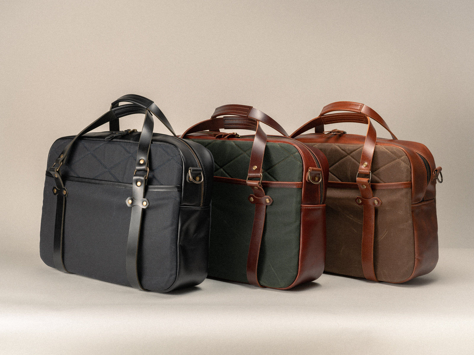 all three colours of the campbellton messenger bag lined up together - black, olive and nutmeg canvas