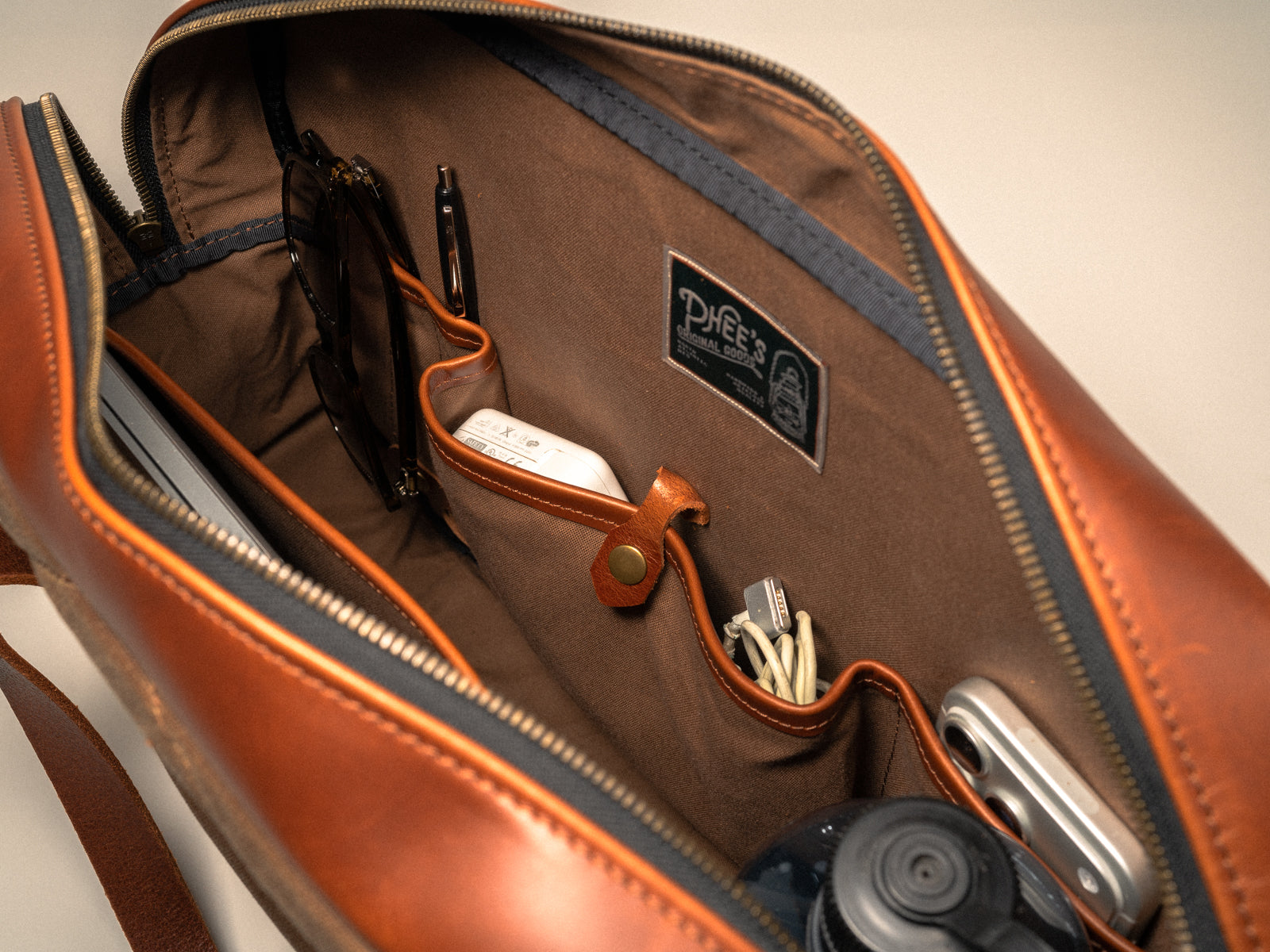 interior shot of the inside of the campbellton messenger bag, showing various size pocket, including charger pocket