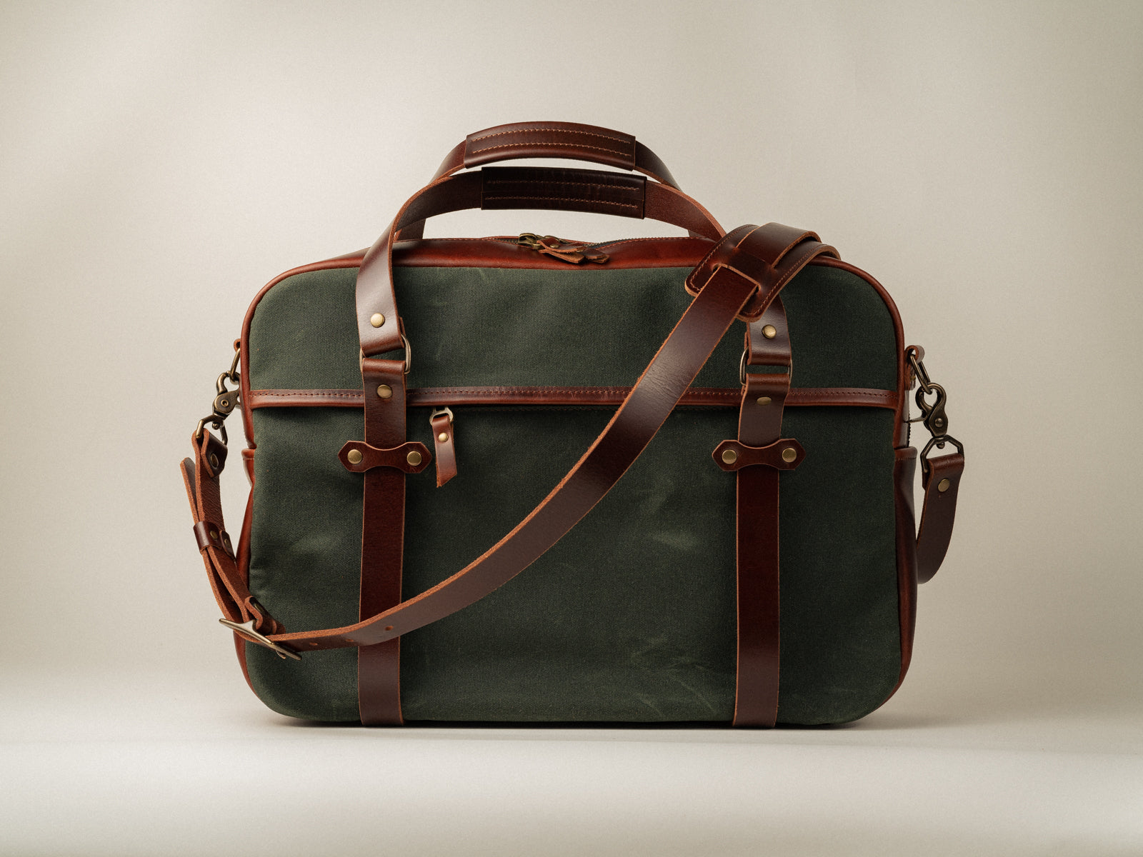 Zippered pocket side view of Campbellton messenger bag in olive canvas with brown leather