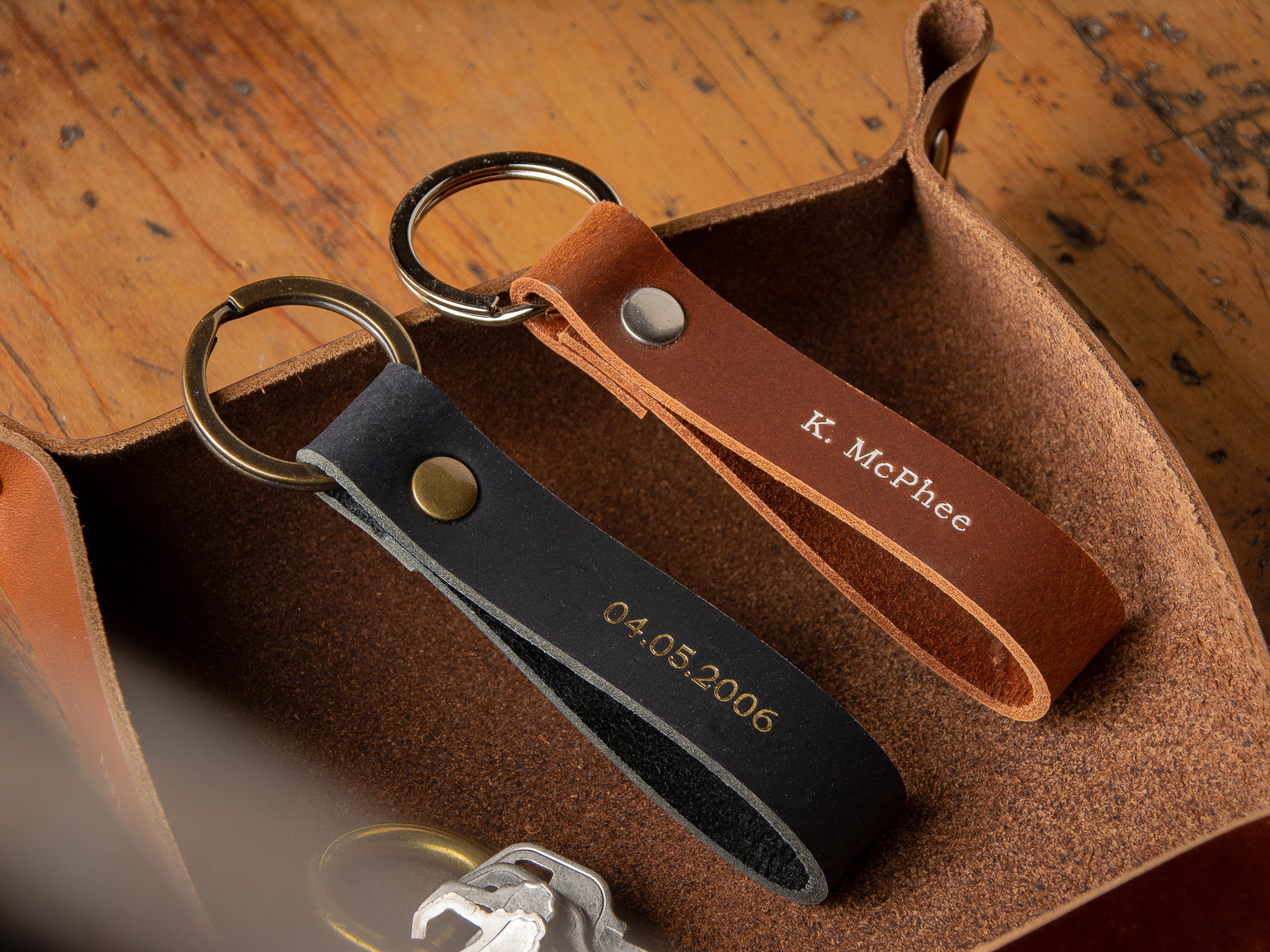 two leather loop keychains customized with a date, and with an full name in foil finish