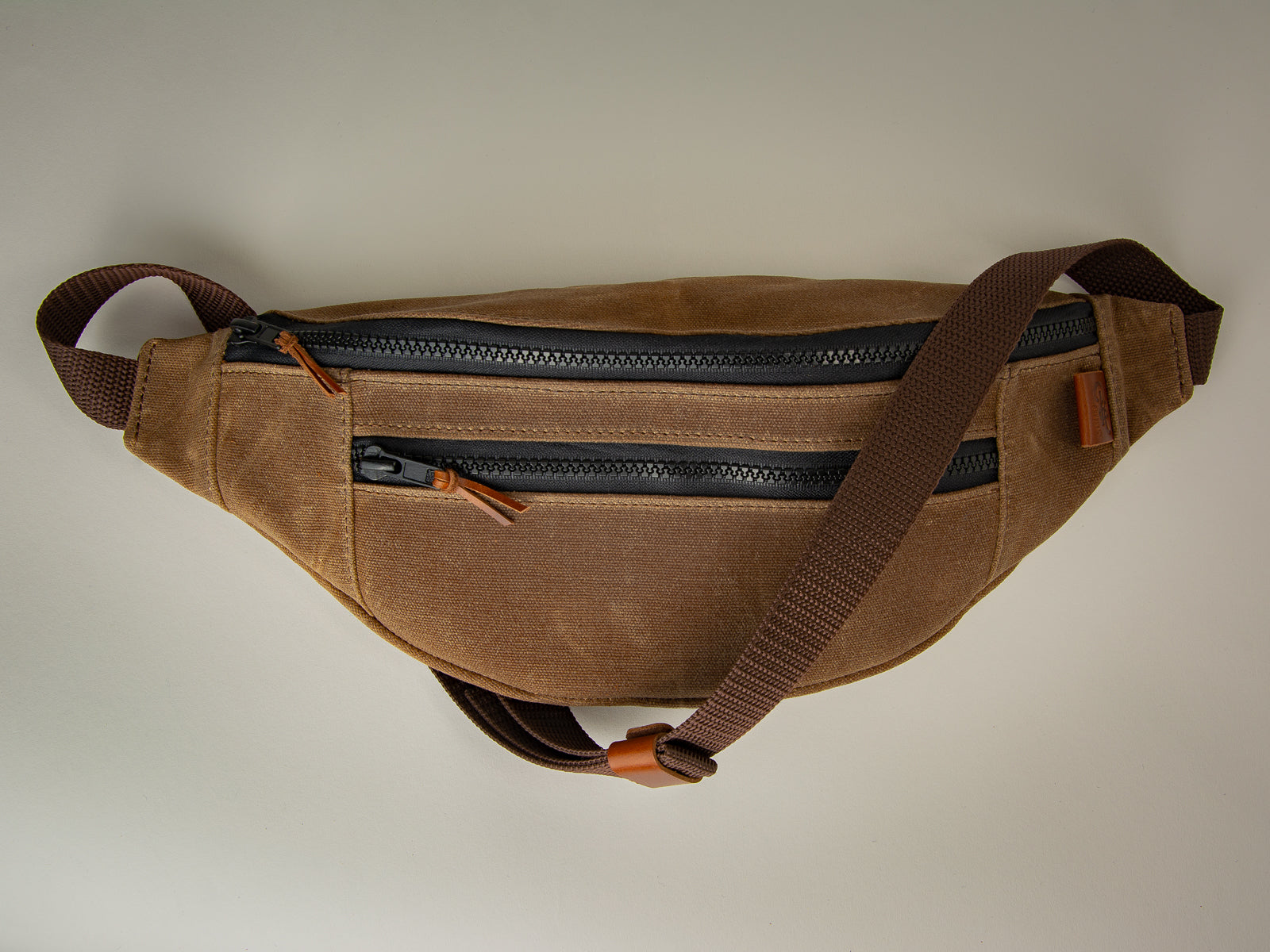 nutmeg brown canvas fanny pack with leather accents for use over shoulder or around waist