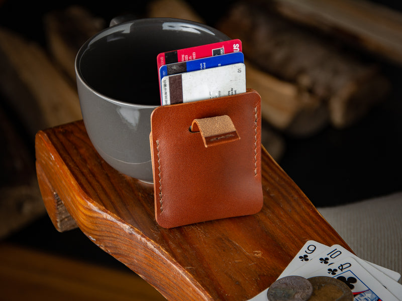 Kenloch pull tab minimalist card wallet sitting on an arm chair in tan full grain leather