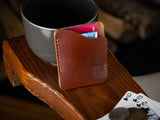 Kenloch pull tab minimalist card wallet sitting on an arm chair in brown full grain leather