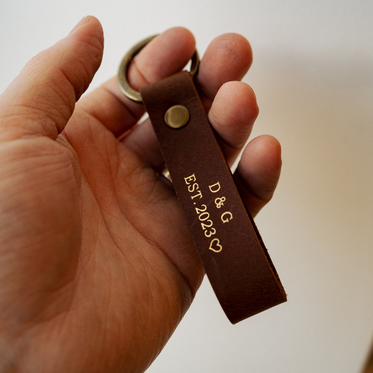 Brown leather keychain embossed with initials and wedding year