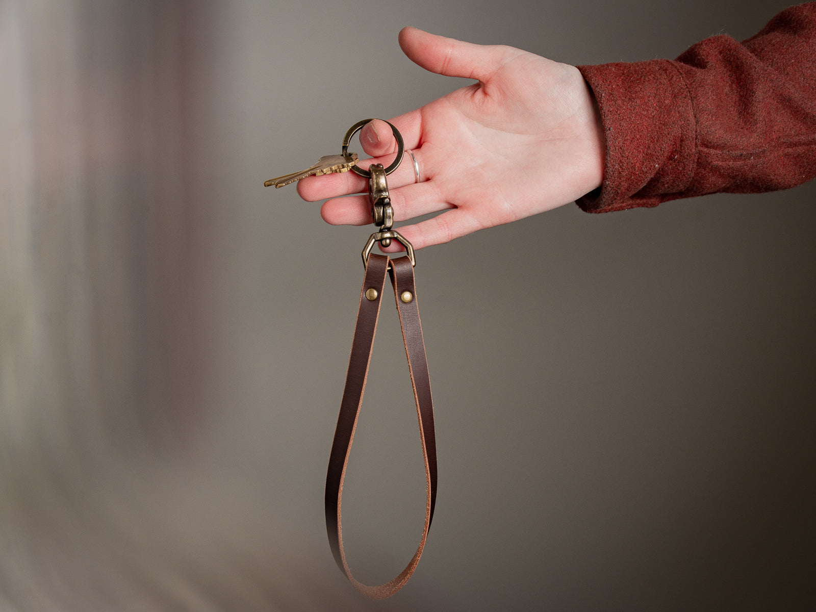 Leather Key Lanyard in brown held in right hand.