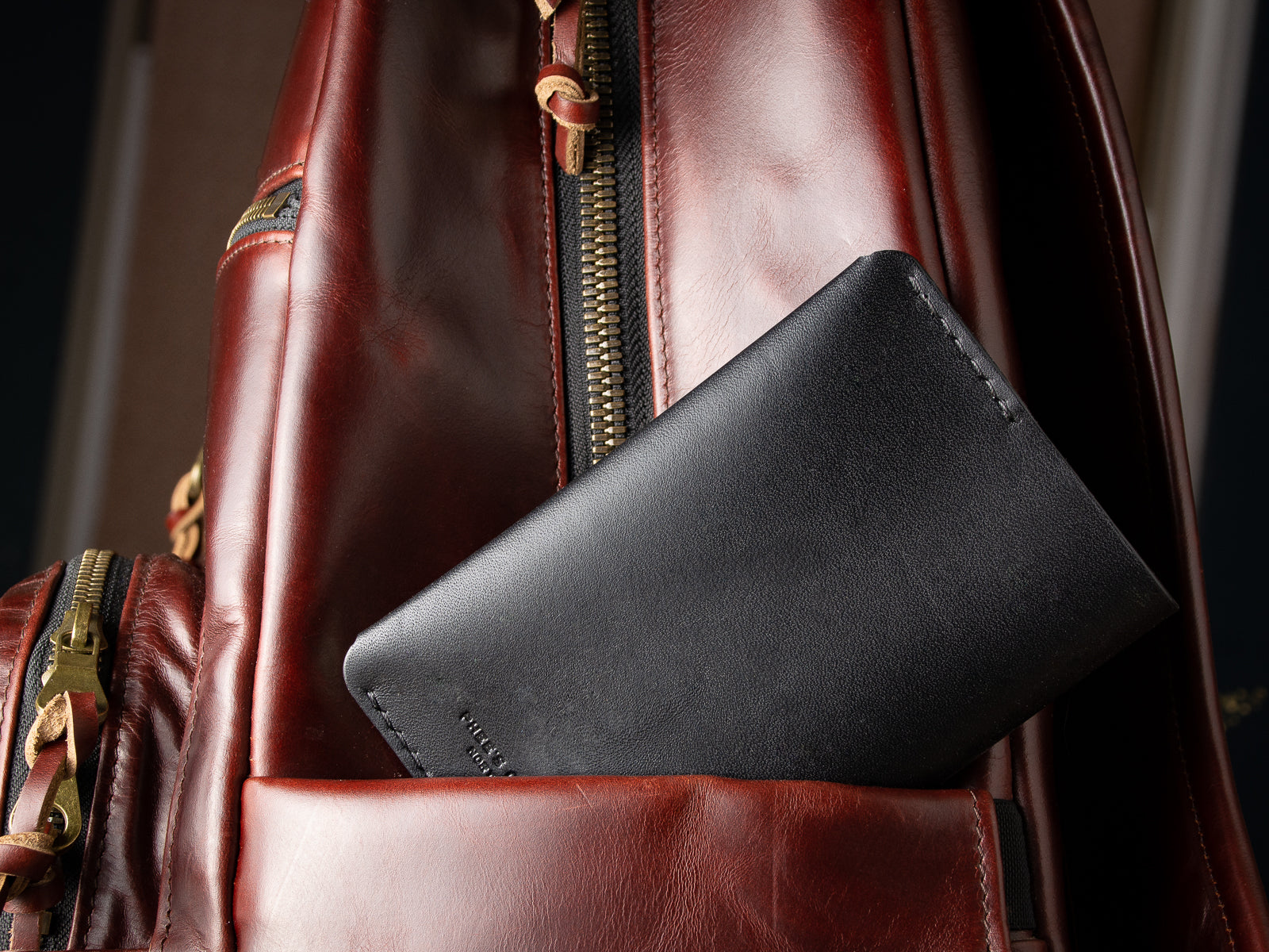 A black passport sleeve poking out of the the pocket of a backpack 