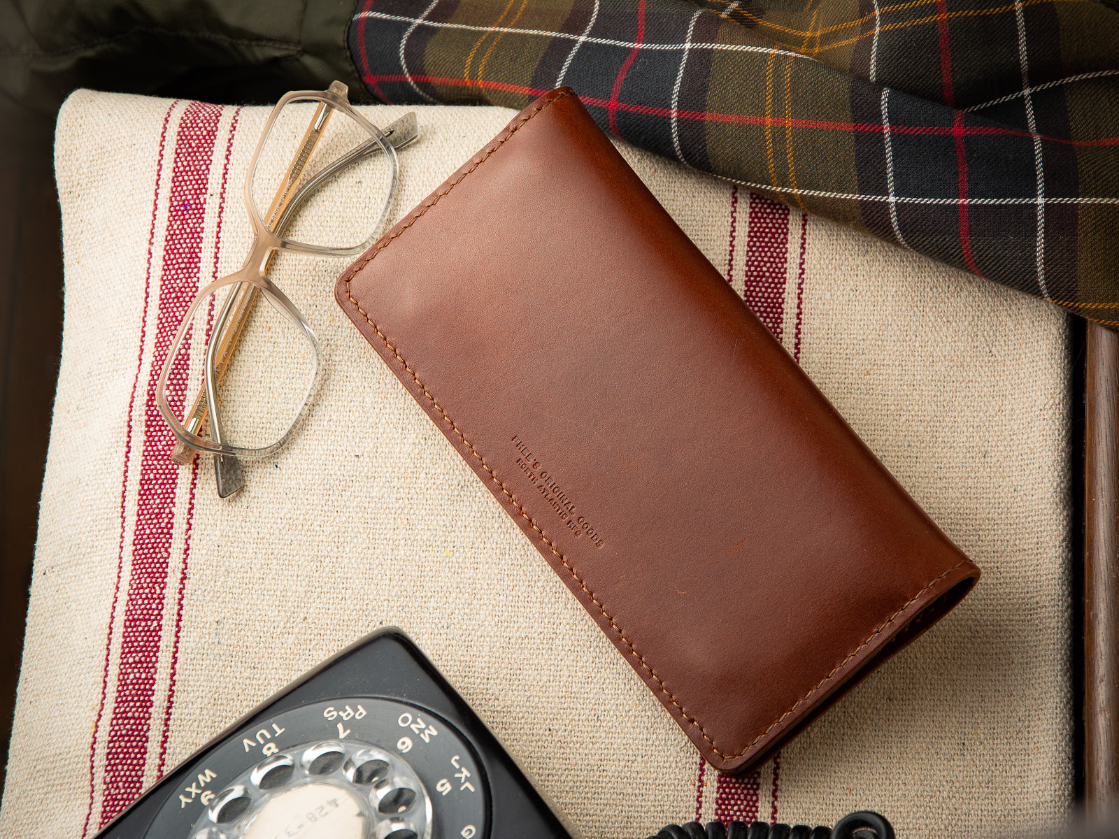 Closed over brown leather Rosedale large wallet sitting on a telephone table