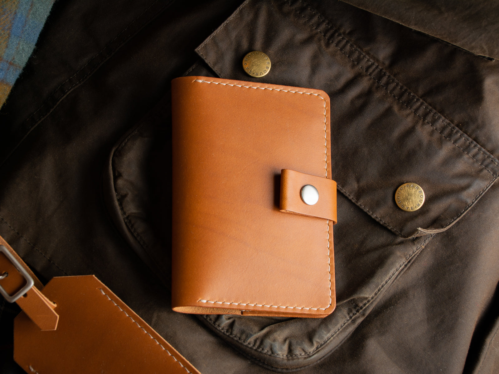 Front of tan veg-tan leather travel wallet with nickel snap