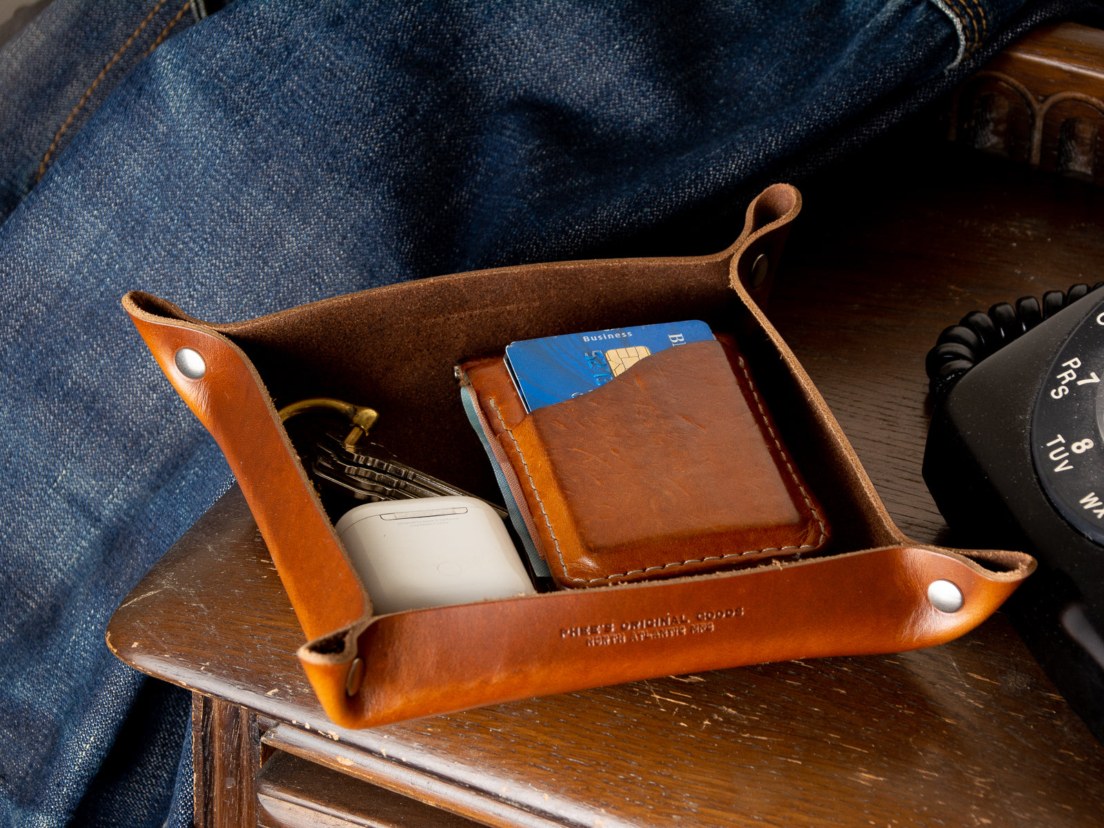 A tan home decor valet tray in full grain leather sitting in a porch 