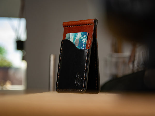 Build Your Own Dunvegan money clip wallet in black and brown sitting on a shelf