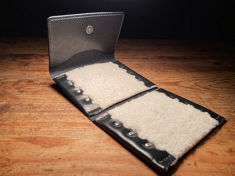 opened up black fly fishing wallet, showing lambskin lined pockets