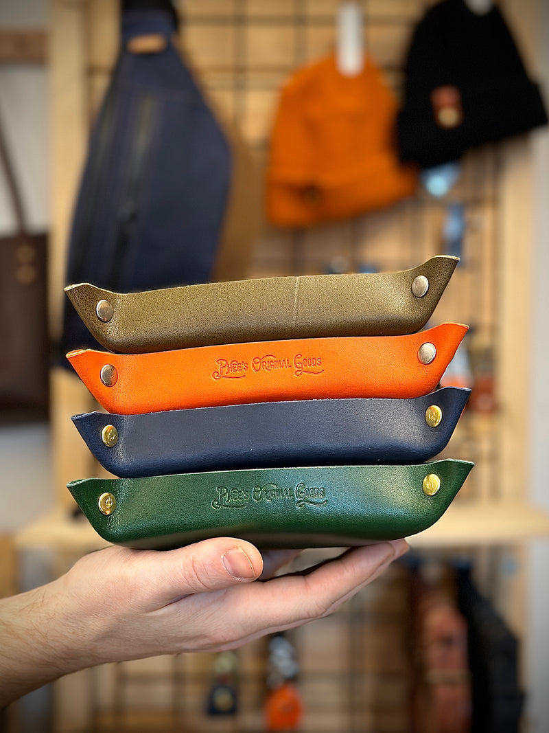 Four colours of the valet tray being held in a hand
